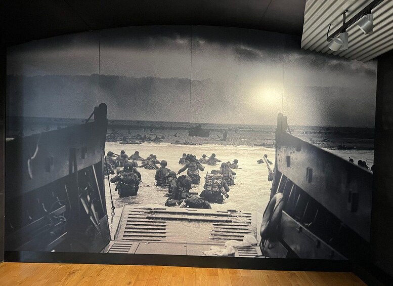A historical scene of soldiers disembarking from a ship onto a beach, with a ship's ramp leading to the shore. 2
