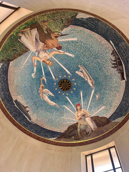 A circular mosaic with mythological figures, a central sun-like symbol, and surrounding stars. 4