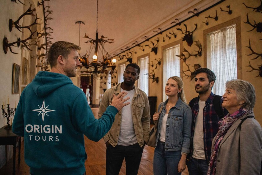 A group of people in a room with deer antlers on the walls. 2