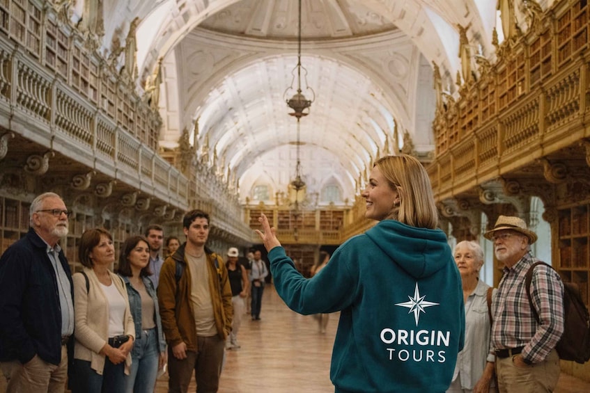 A group of people in a grand, ornate building with high ceilings and intricate architectural details. 1
