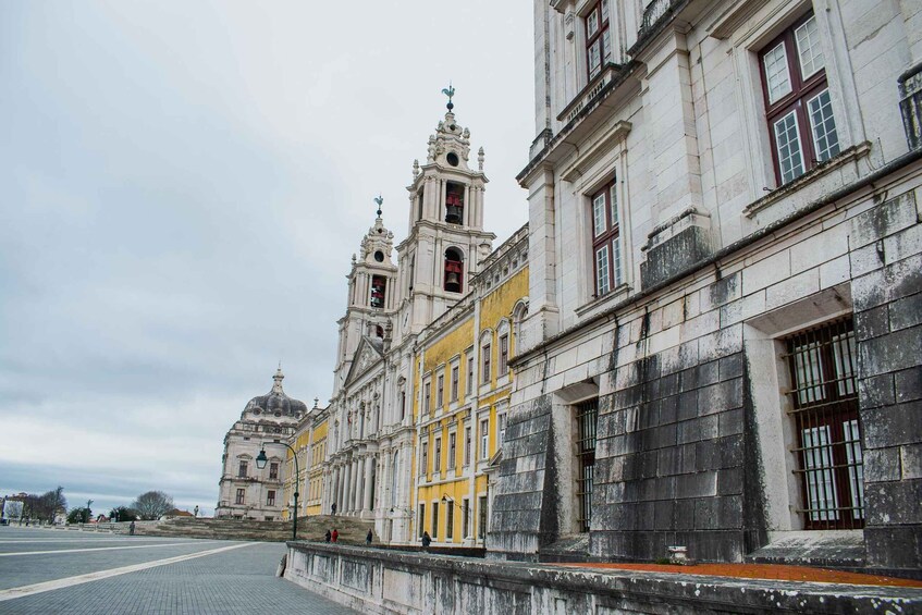 A historic building with a yellow facade and a large dome, surrounded by a paved area. 5