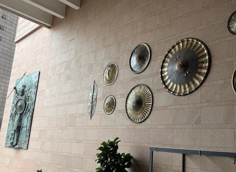 A wall with various metal plates and a bronze statue. 5