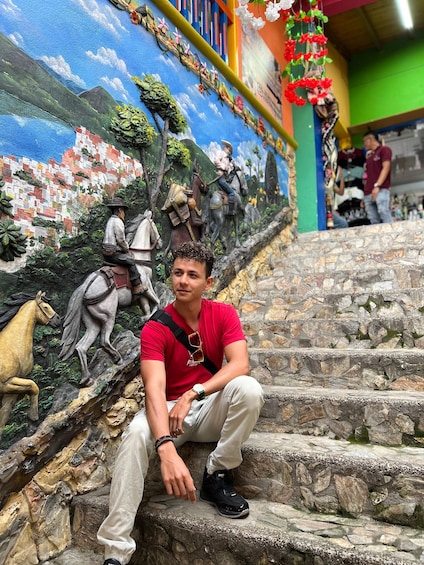 A person sitting on stone steps with a mural of a horse and rider in the background. 5