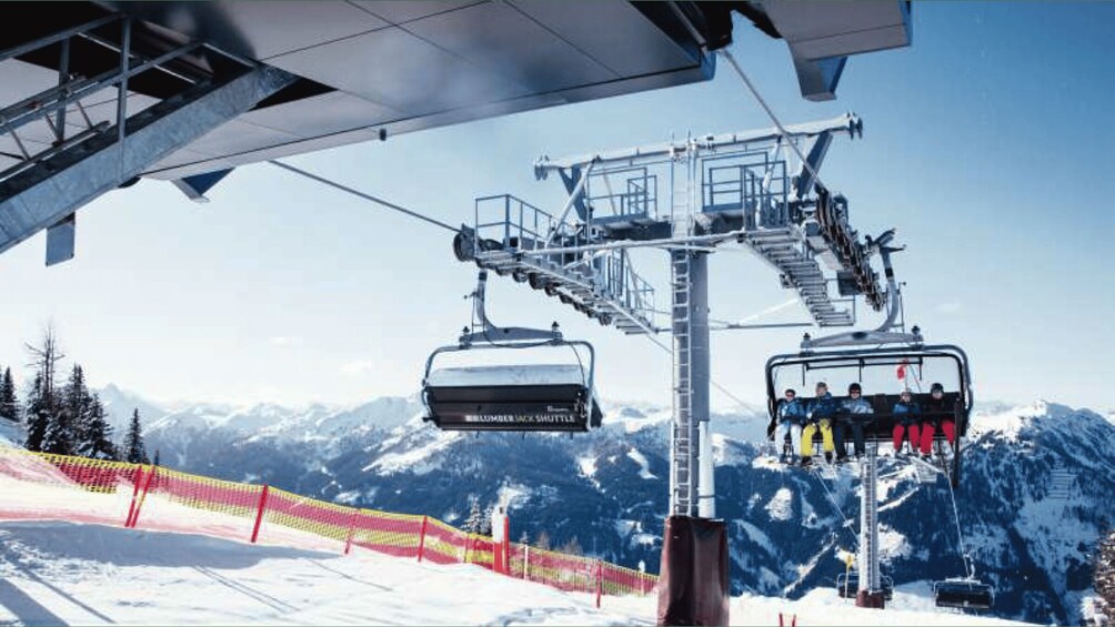 A ski lift with cabins and a chairlift against a mountainous backdrop. 5