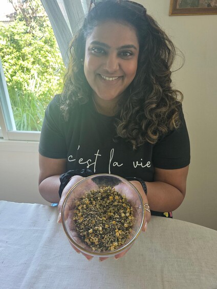 A person holding a bowl of dried herbs. 1