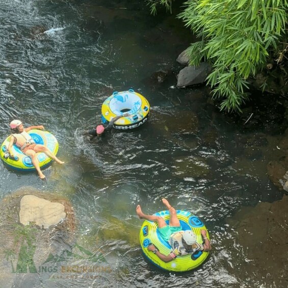 Two people floating on inflatable tubes in a river. 3