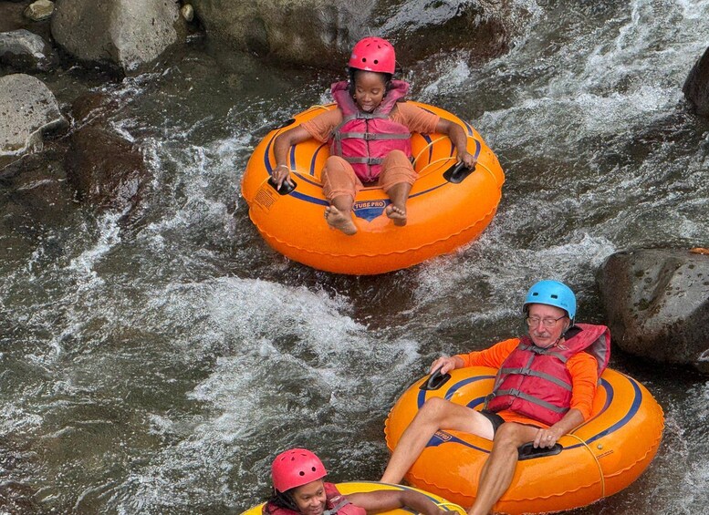 People rafting down a river on inflatable tubes. 4