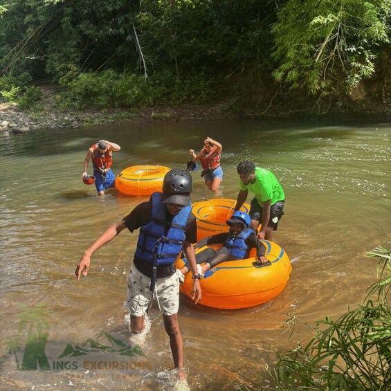 People in inflatable rafts on a river surrounded by dense greenery. 5