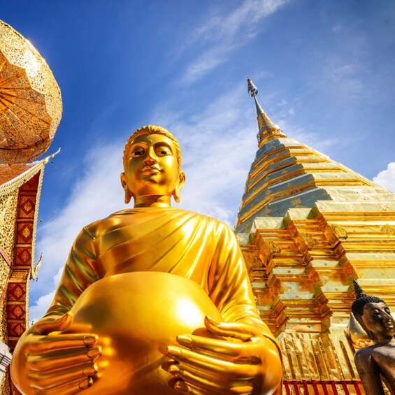 Een gouden Boeddhabeeld dat een bol vasthoudt, met een pagode op de achtergrond. 4