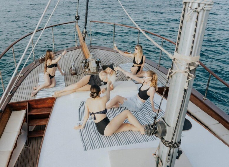 A group of people lounging on a boat deck with a view of the water. 5