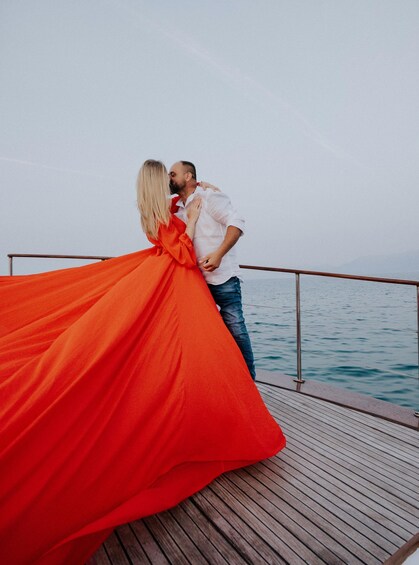 A couple embracing on a wooden deck by the water. 3