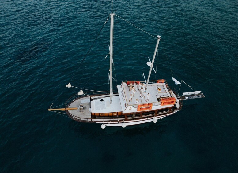 A large boat with multiple masts and a cabin, floating on a body of water. 1