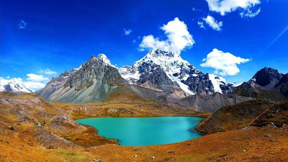 A mountain range with a turquoise lake in the foreground. 3