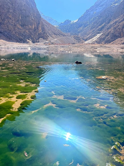 A clear mountain lake with reflections, surrounded by rugged mountains. 3