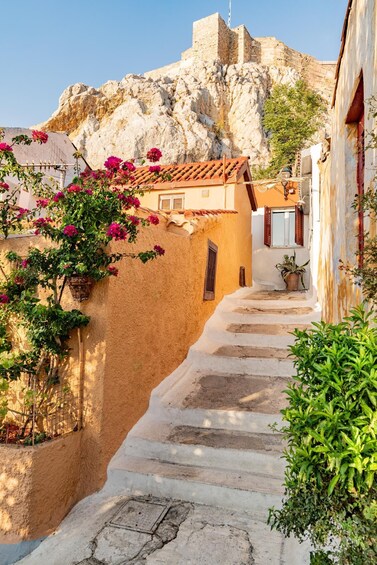 A stone staircase leading up a hillside with a building and a rocky outcrop in the background. 2