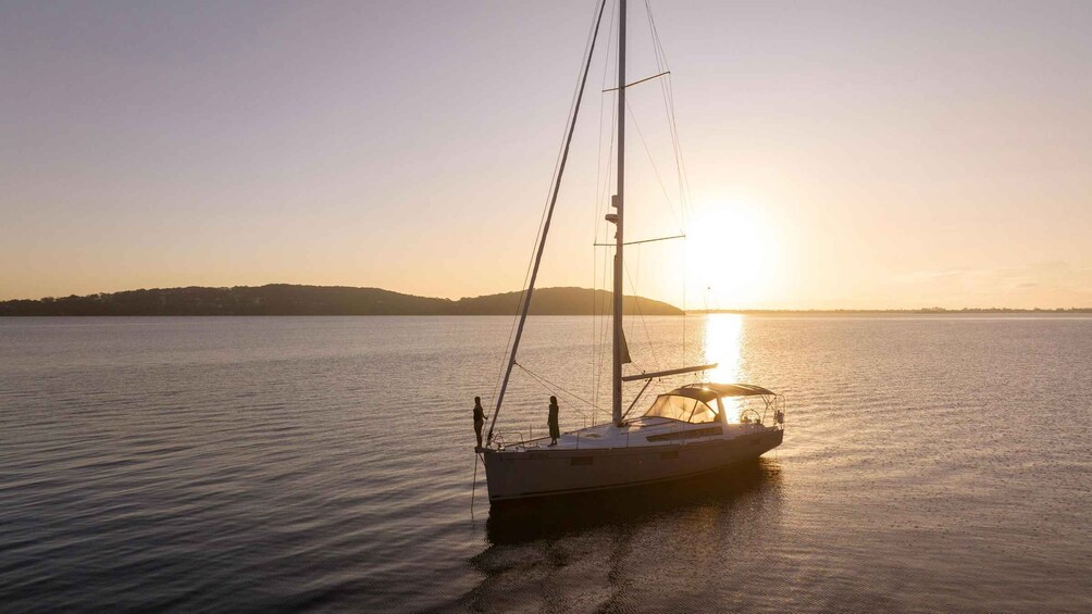 A sailboat on calm waters with a sunset in the background. 3