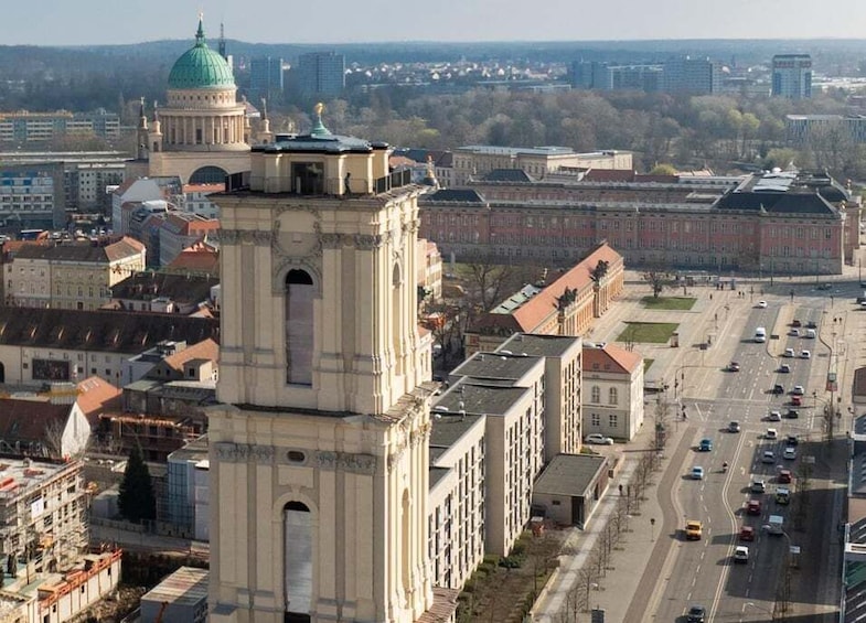 A cityscape with a prominent tower and dome, surrounded by buildings and a busy street. 1