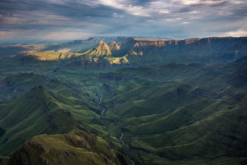 A mountain range with a prominent peak and a valley with a river. 5