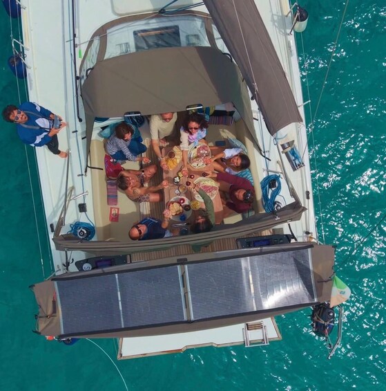A group of people on a boat with a dining table and solar panels. 2