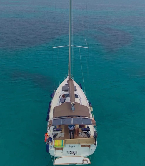 A sailboat with a mast and sails, surrounded by turquoise water. 4