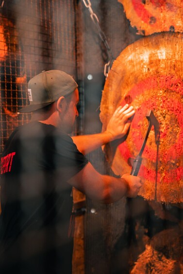 A person using a hammer to break a large, round object. 5