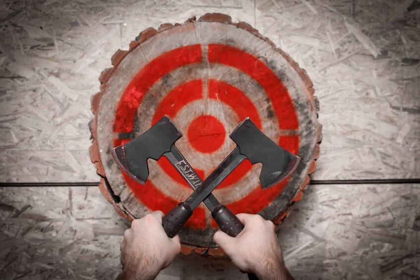Two crossed axes on a wooden target with a bullseye. 1