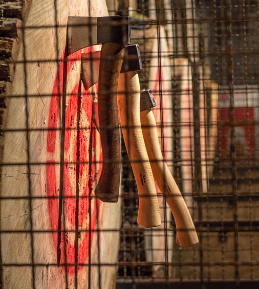 Two axes hanging on a wall with a red target. 2