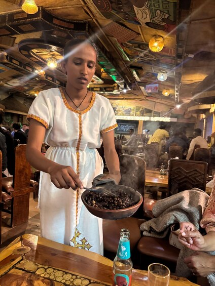 A person serving food in a restaurant with a traditional interior. 2