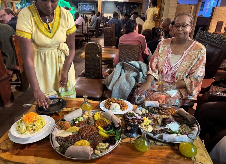 A traditional Ethiopian meal with various dishes on a large platter, including injera, stews, and salads. 4