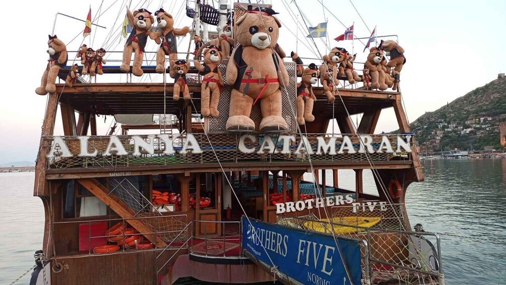 A boat named 'ALANIA CATAMARAN' with multiple teddy bears on deck and a 'BROTHERS FIVE' sign. 1