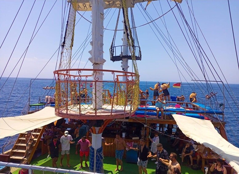 A ship with a central mast, multiple decks, and passengers enjoying the view. 4