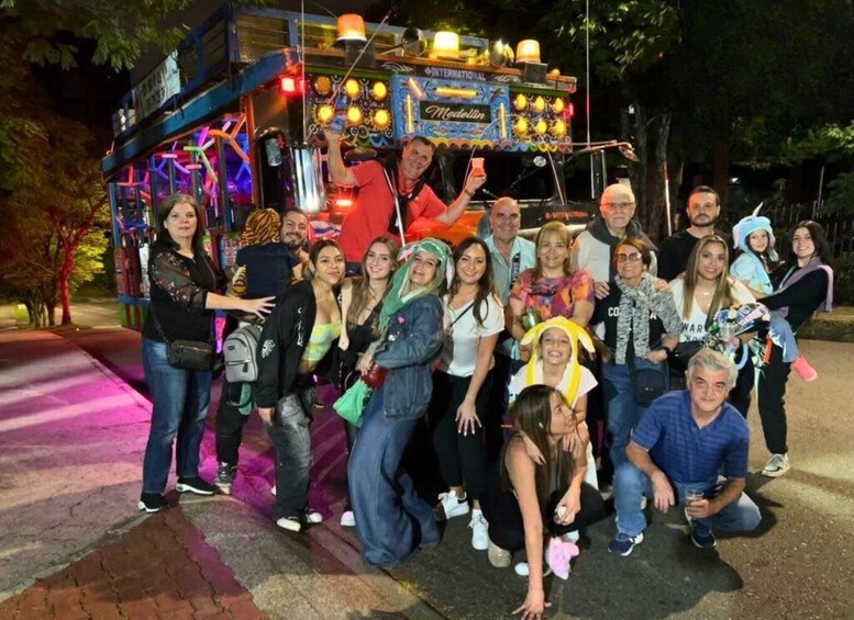 A group of people posing in front of a brightly lit food truck with a neon sign. 5