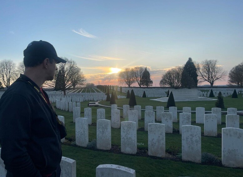 A cemetery with rows of headstones and a person standing in the foreground. 5