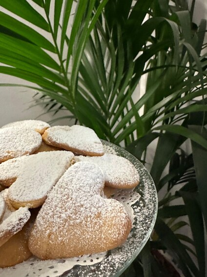 A plate of heart-shaped cookies dusted with powdered sugar. 1