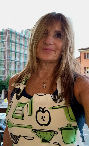 A person wearing a colorful apron with kitchen-themed designs. 3