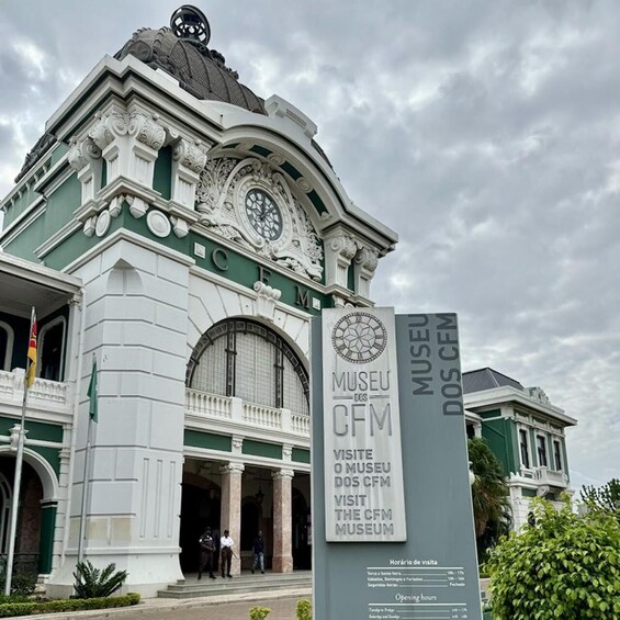 The entrance to the Museu dos CFM with ornate architectural details and a sign indicating visiting hours. 1