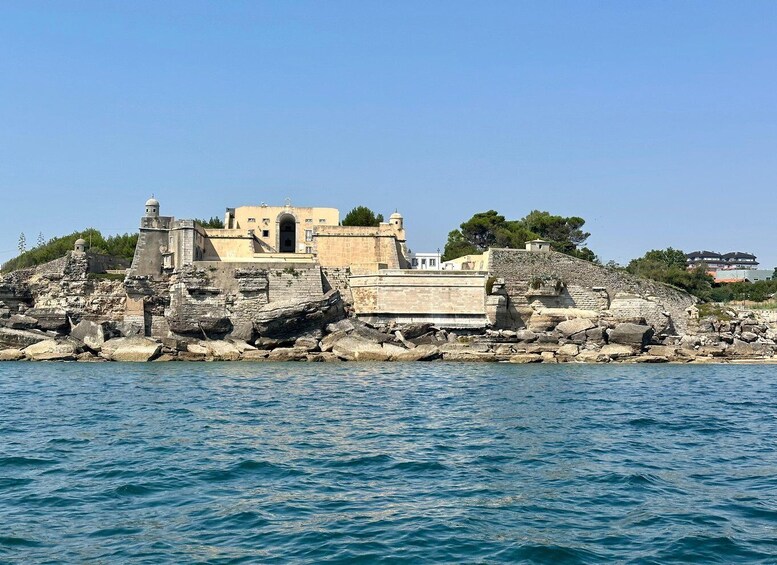 A coastal fortress with ancient architecture, a clear sky, and calm sea. 3