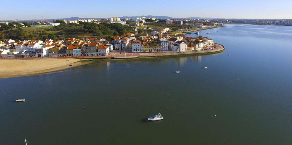 A coastal town with buildings along the waterfront, boats in the water, and a sandy beach. 4
