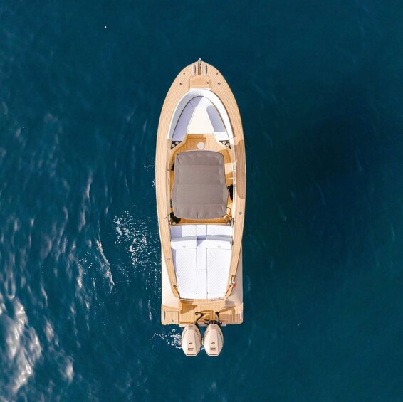 A small wooden boat with a canopy and two outboard motors, floating on calm water. 1