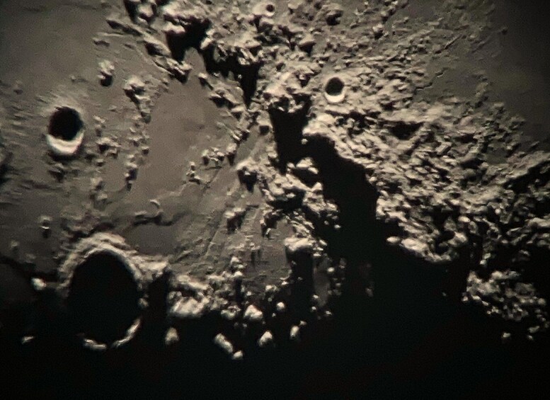 A lunar surface with craters and rough terrain. 3
