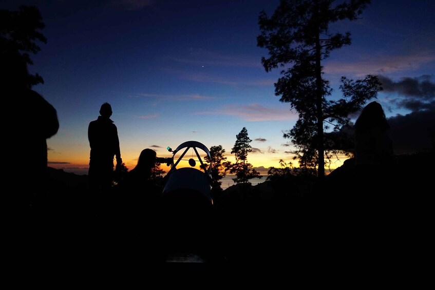 A silhouette of a person with a backpack, a tent, and trees against a sunset sky. 2