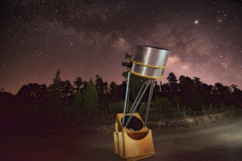 A telescope set up outdoors with a starry night sky in the background. 5