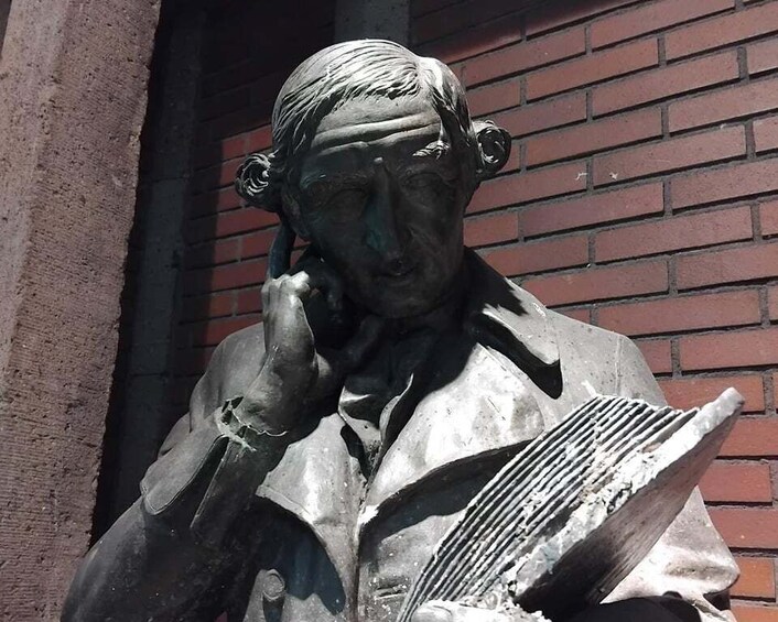 A statue of a man holding a book and a telephone. 4