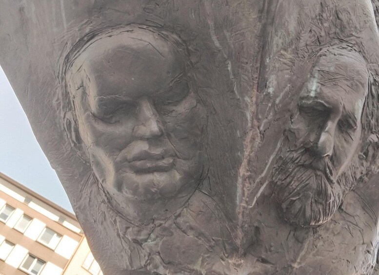 A close-up of a stone sculpture with two faces carved into it. 3