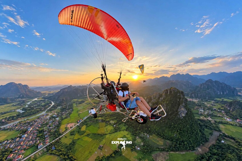 A paraglider over a mountainous landscape with a sunset. 4