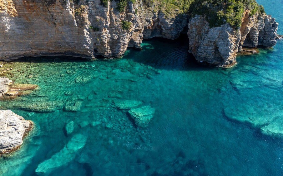 A coastal cliff with clear turquoise waters and rocky formations. 3