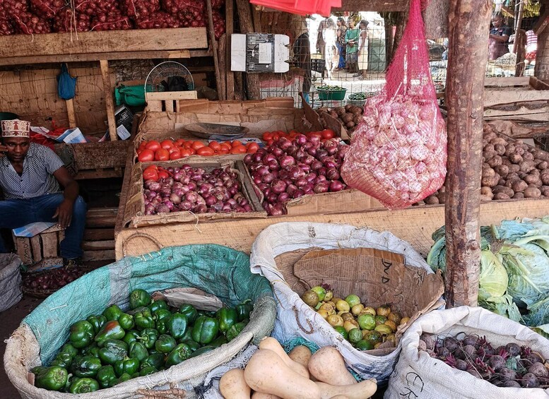 A market stall with various vegetables like tomatoes, onions, and peppers. 5