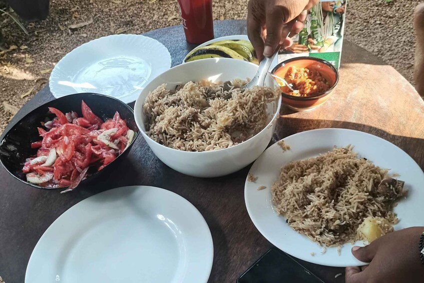 A table with various dishes including rice, a bowl of red meat, and a bowl of curry. 1