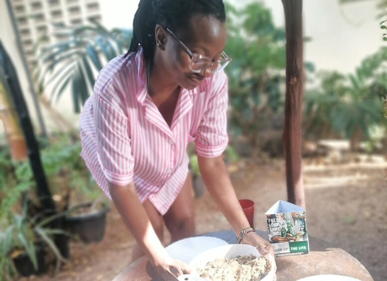 A person preparing food outdoors, with a bowl of rice and a carton of milk on a table. 3
