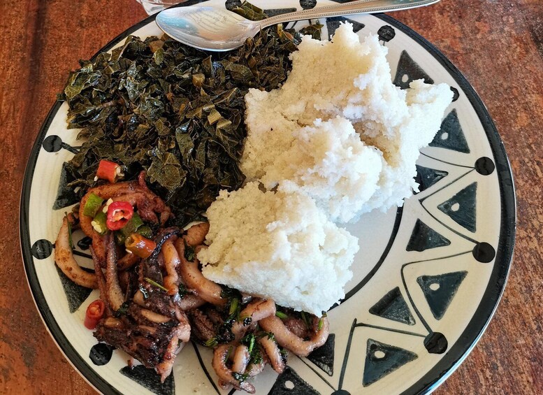 A plate with rice, sautéed squid, and cooked greens. 2
